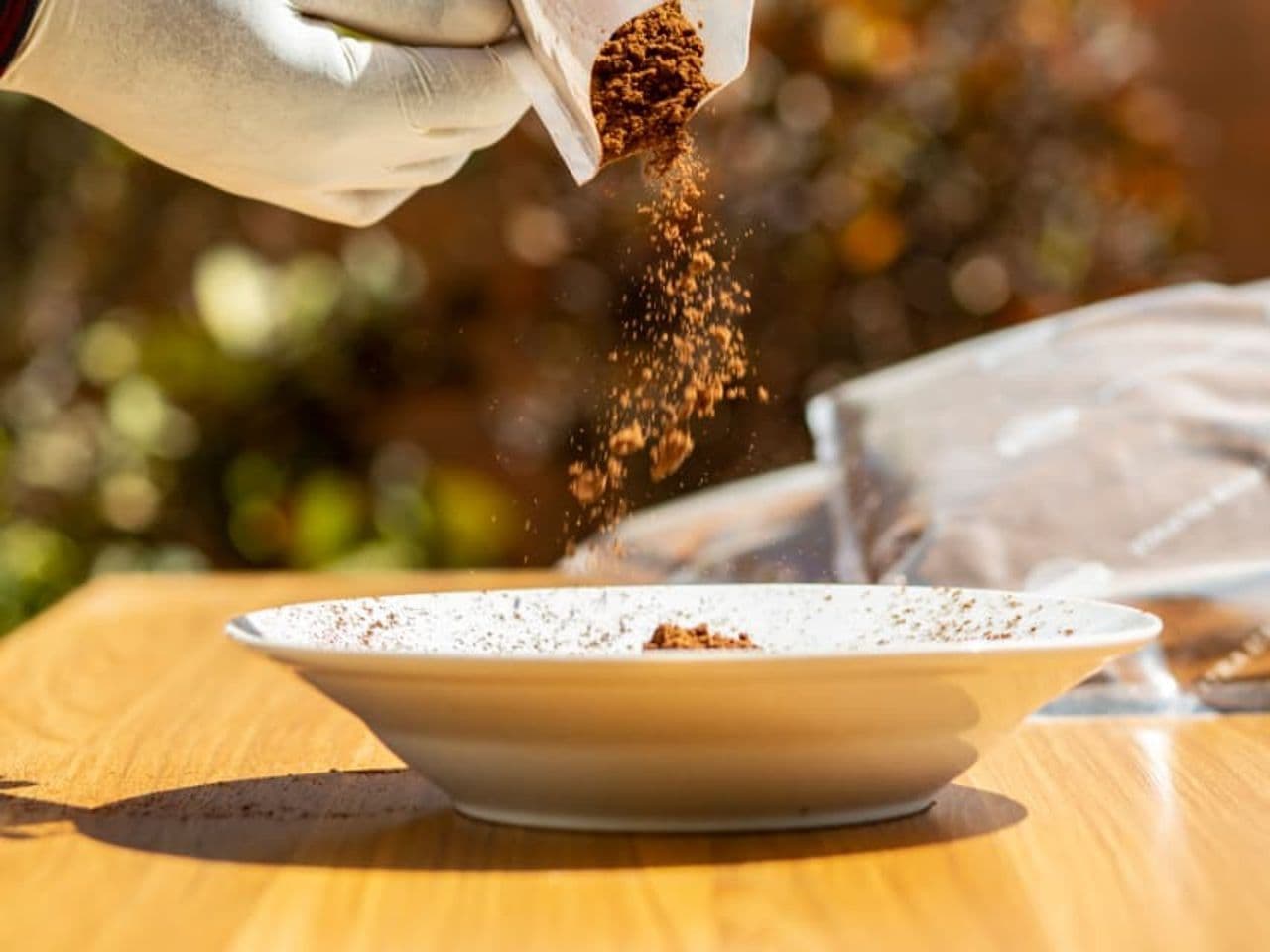 Madagascar vanilla bean powder being poured into a bowl, food-grade handling